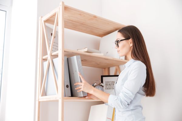 Woman putting a folder one shelf
