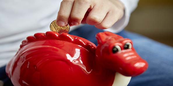 Child saving with a Dylan the dragon money box